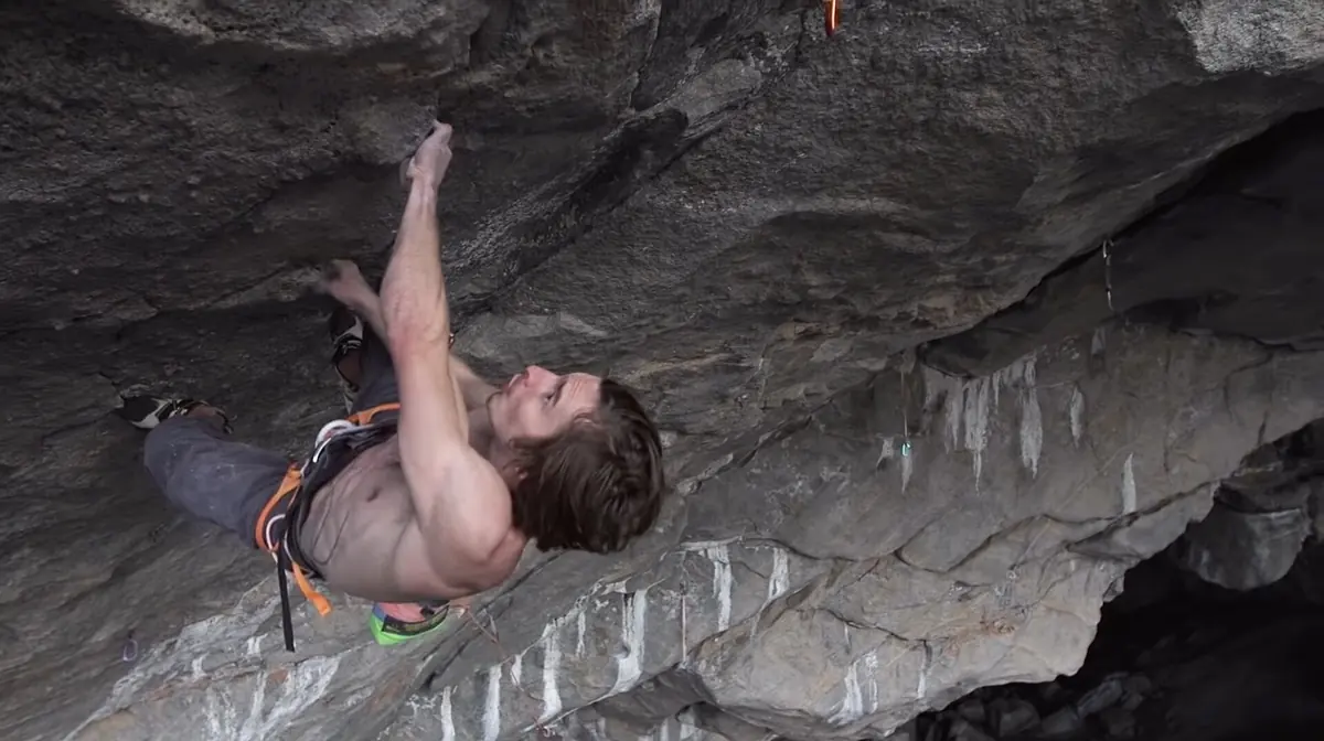 Daniel Woods climbing the steep roof of a cave